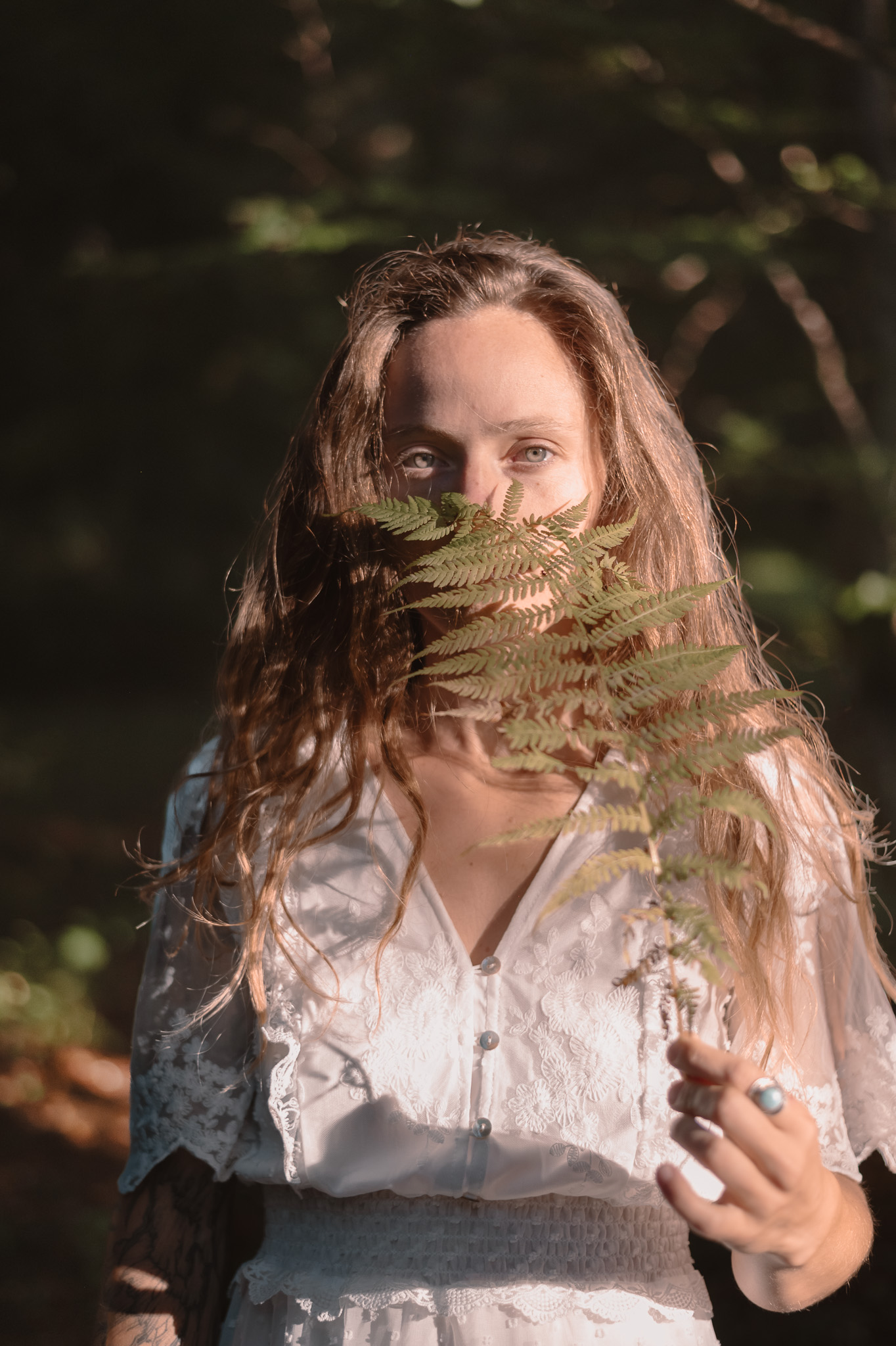 Portrait bohème en forêt, lumière douce et naturelle.