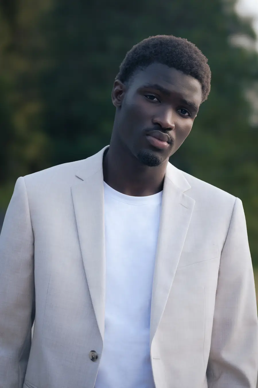 Photographe fashion, éditorial nature en foret avec mannequin peau noire habillé en blanc