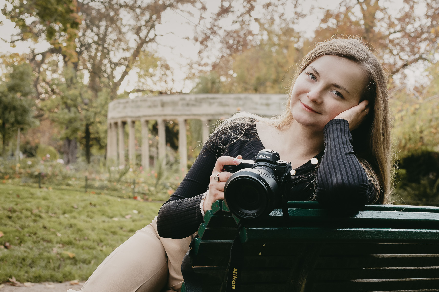 Fondatrice souriante derrière son ordinateur portable, dans une grande salle à lustres et verrières