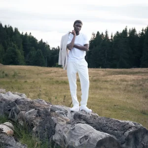 Photographe fashion, éditorial nature en foret avec mannequin peau noire habillé en blanc